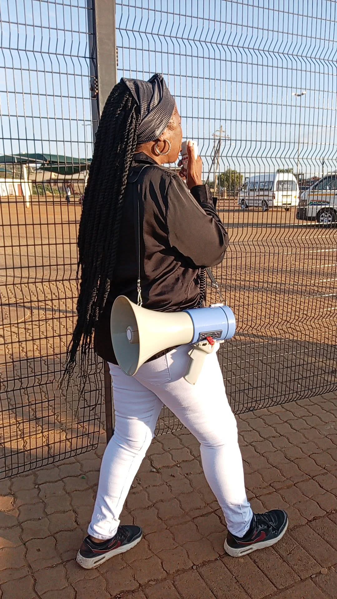 Pastor Cecelia preaching with a megaphone in the streets